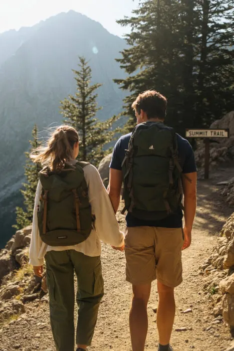 Hiking hand-in-hand – scenic mountain trail couple pose