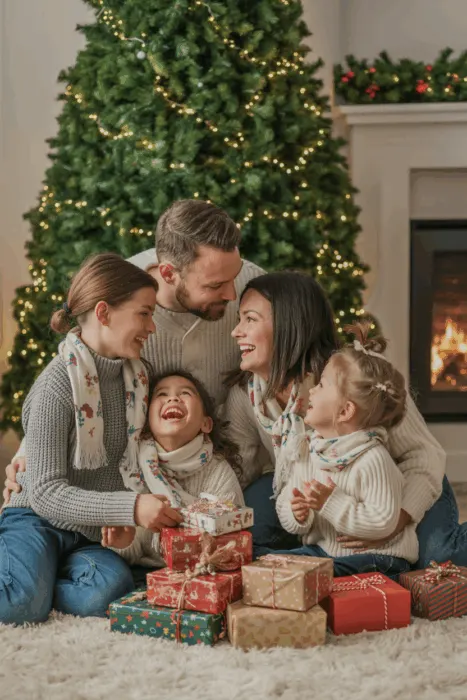 Joyful indoor Christmas family photoshoot with winter outfits and holiday decorations.