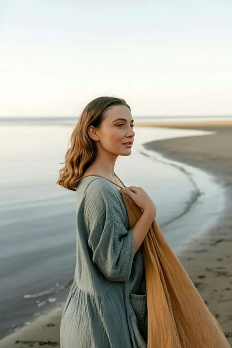 Woman standing near the ocean for a mermaid-inspired birthday photo.