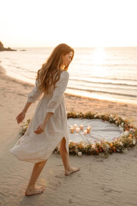 beach 21st birthday photoshoot at sunset with white dress and flowers