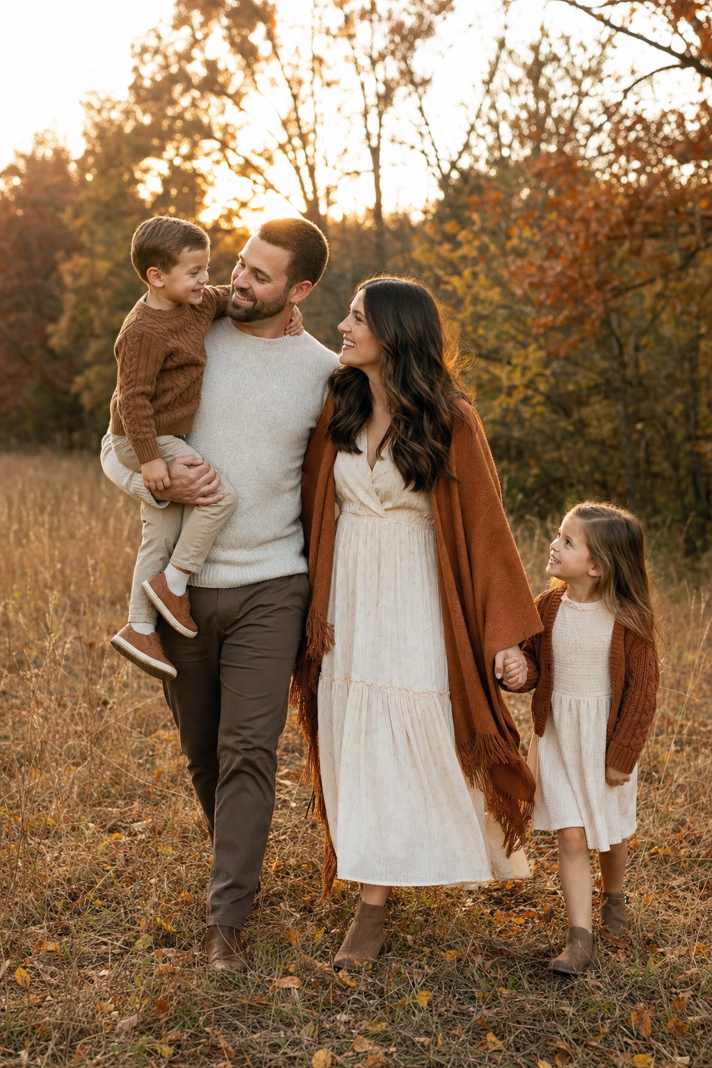 Family of four in neutral fall photo outfits &mdash; cream, camel and rust in golden autumn light